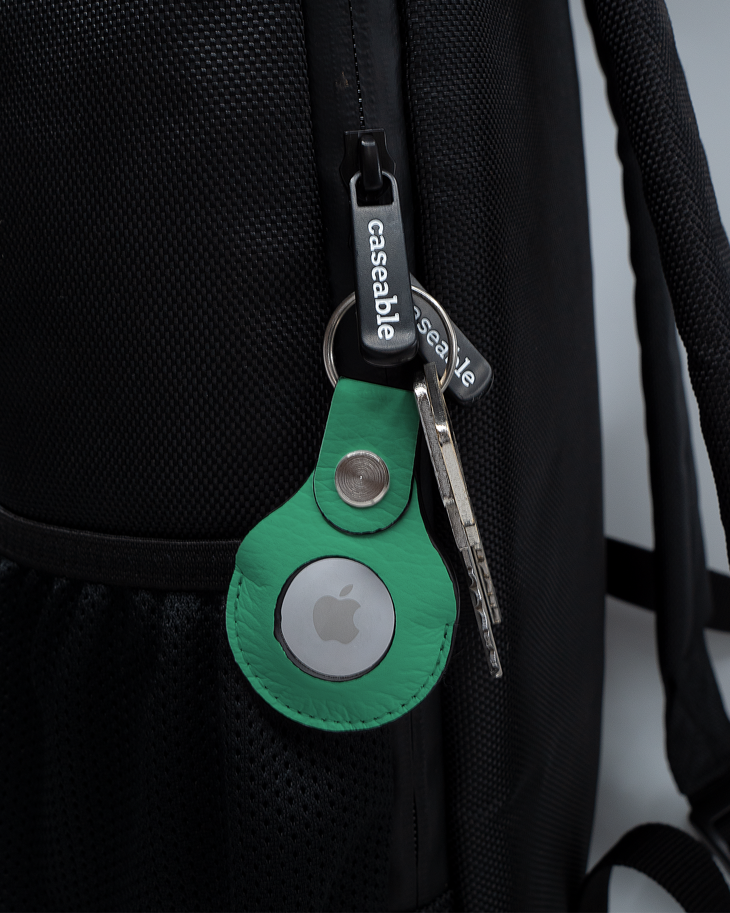 AirTag Holder with design ISG Neon Green attached to a bag