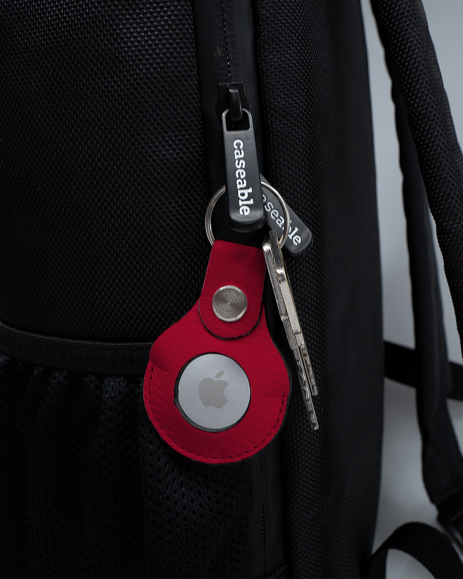 AirTag Holder with design RED attached to a bag