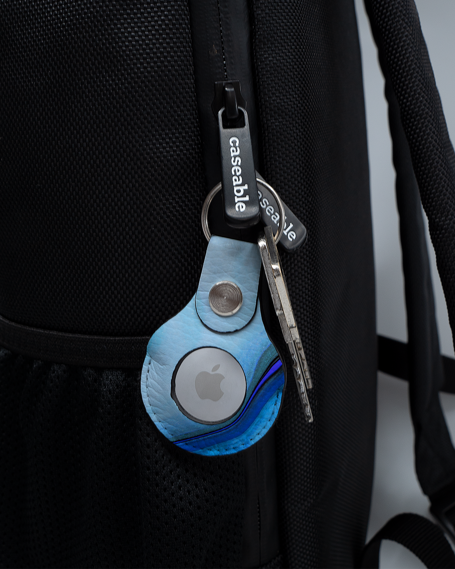 AirTag Holder with design Cool Blues attached to a bag