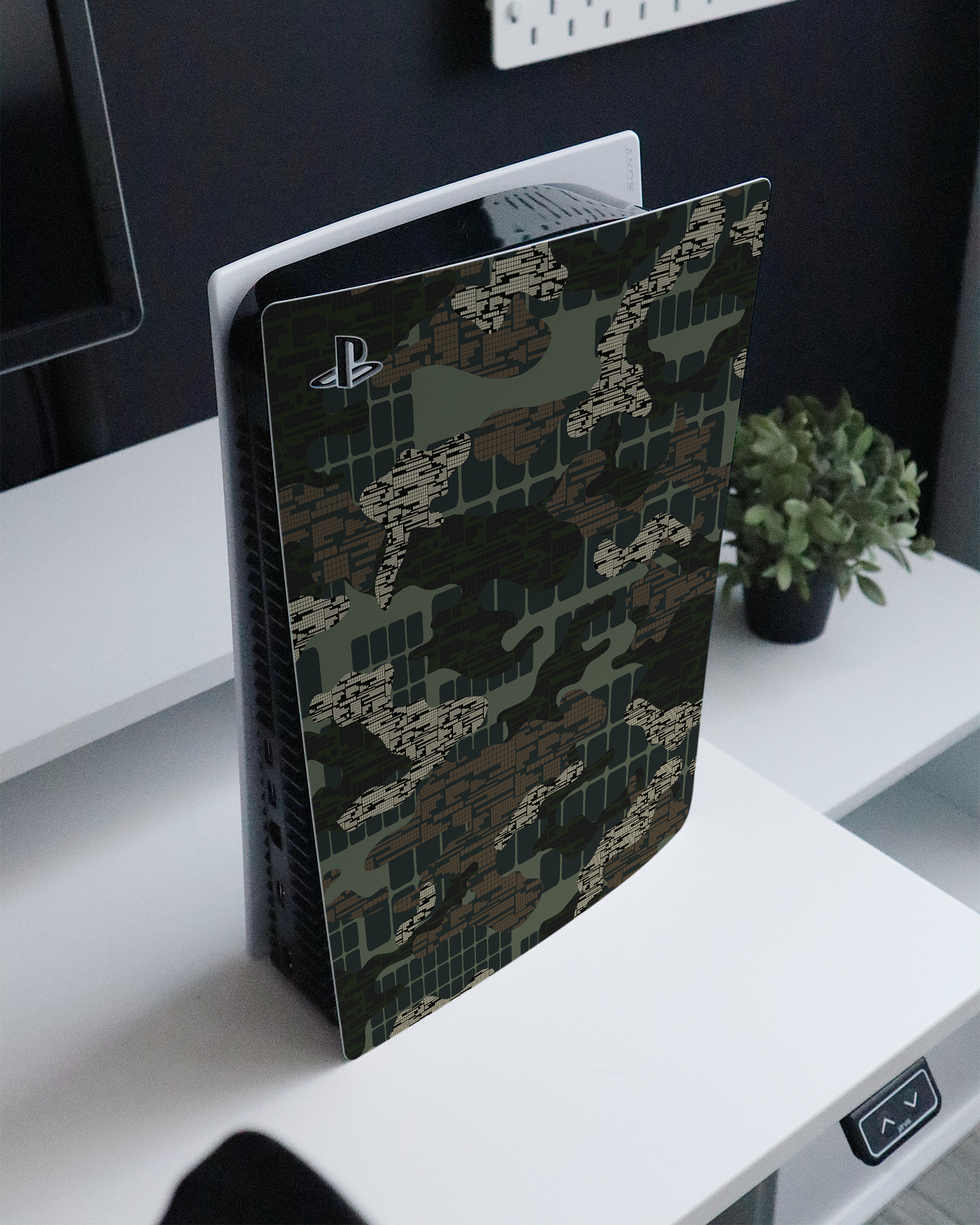 Green Camo Mix Console Skin for Sony PlayStation 5 Digital Edition standing on a sideboard 