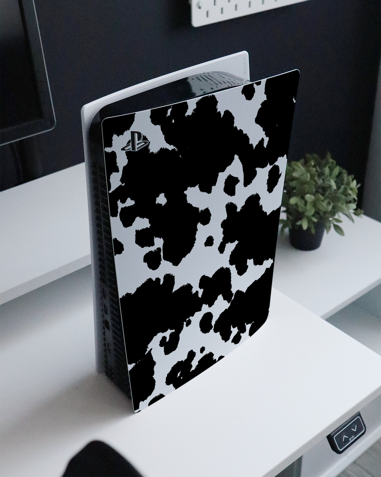 Cow Print Console Skin for Sony PlayStation 5 Digital Edition standing on a sideboard 