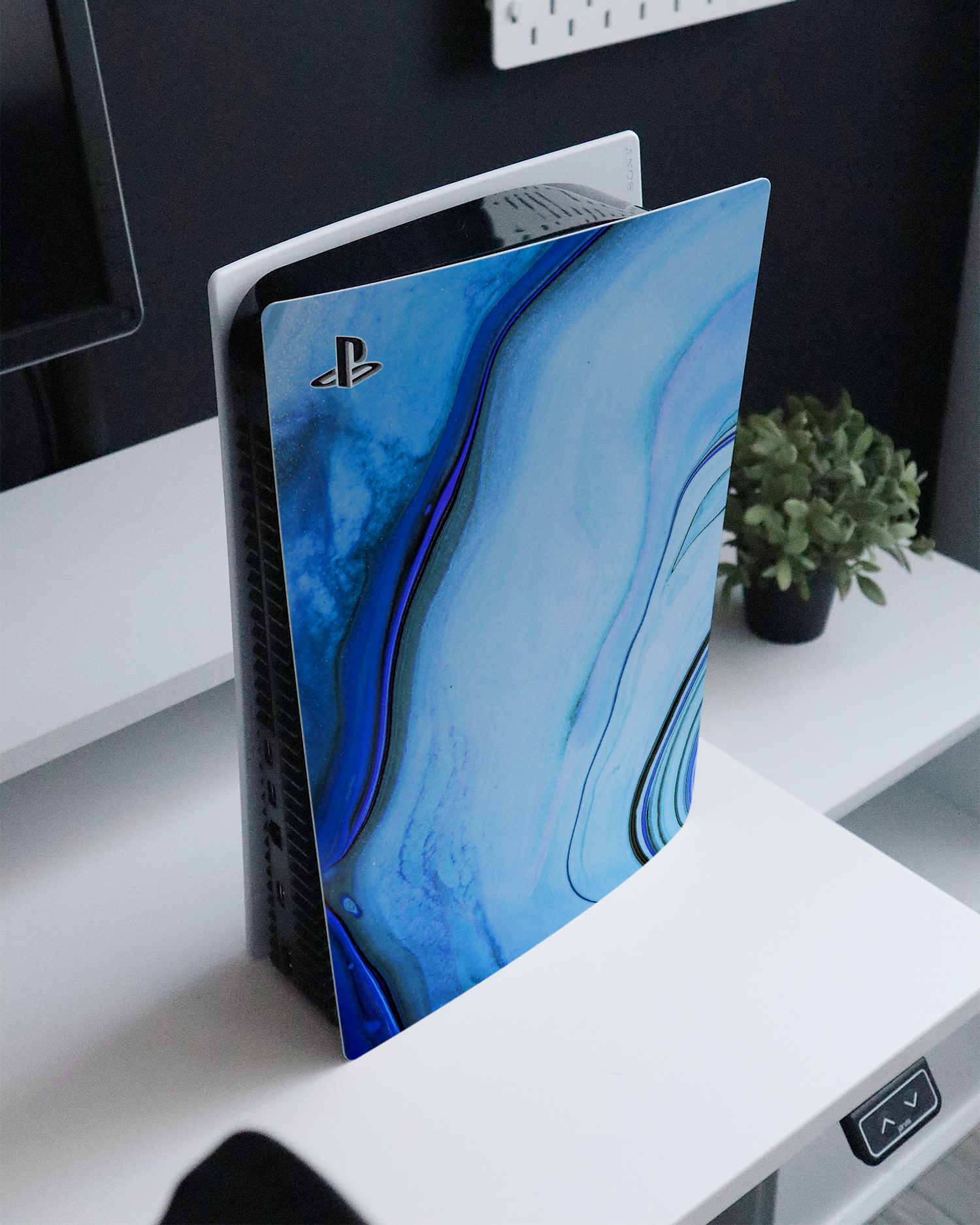 Cool Blues Console Skin for Sony PlayStation 5 standing on a sideboard 