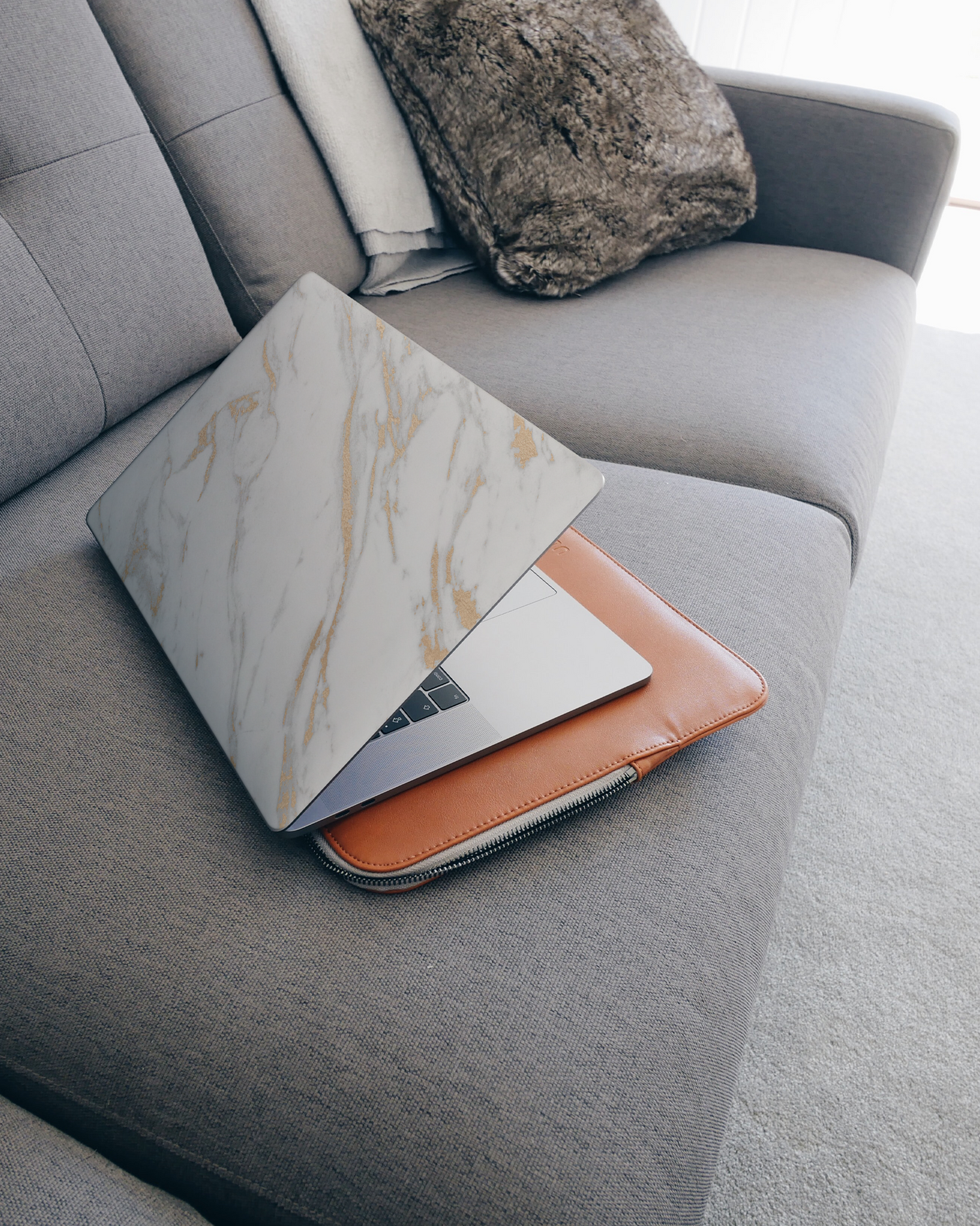 Gold Marble Elegance Laptop Skin for 15 inch Apple MacBooks on a couch