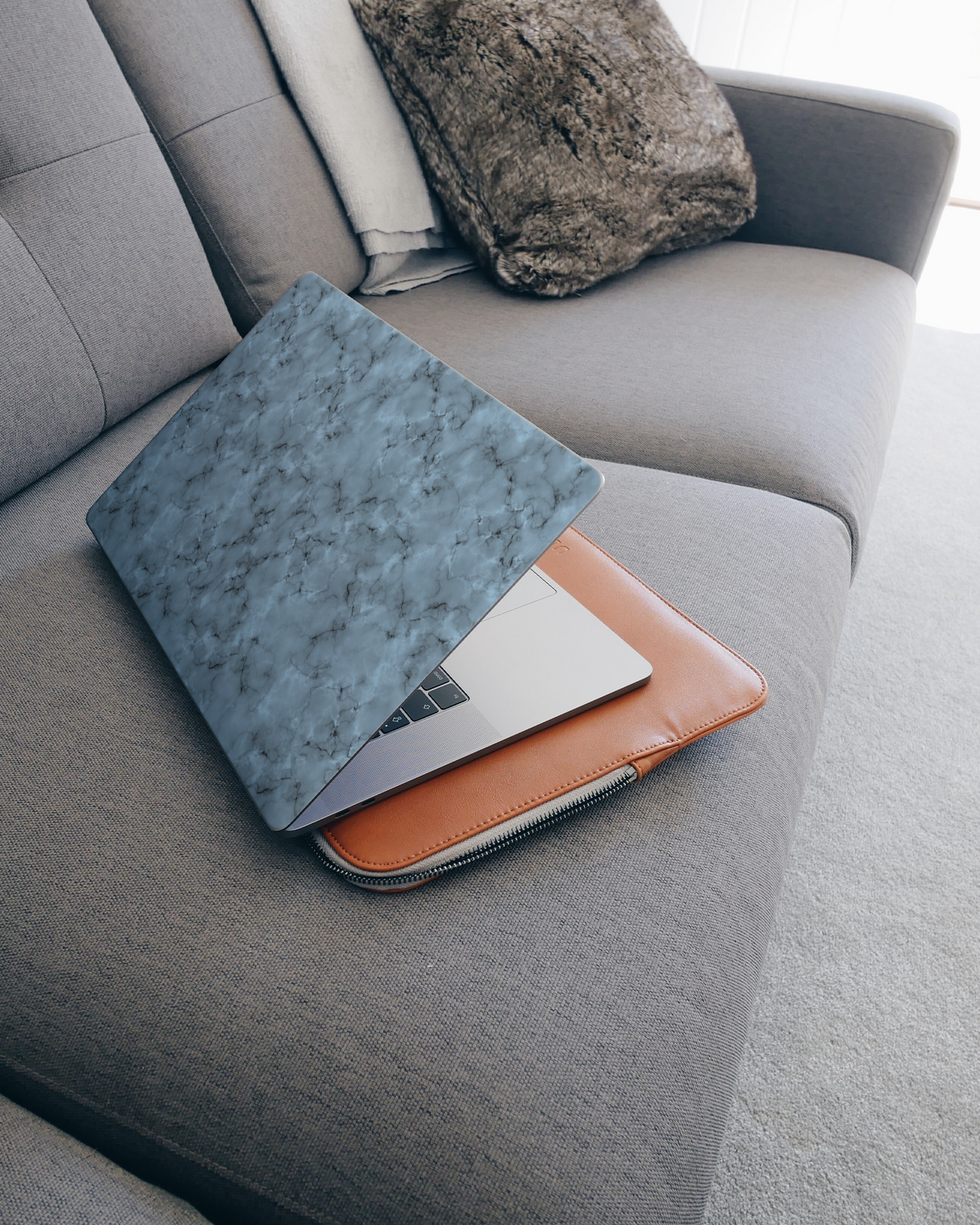 Blue Marble Laptop Skin for 15 inch Apple MacBooks on a couch