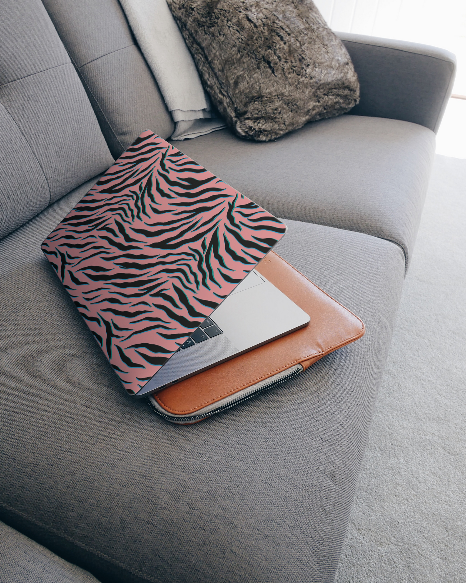 Pink Zebra Laptop Skin for 15 inch Apple MacBooks on a couch