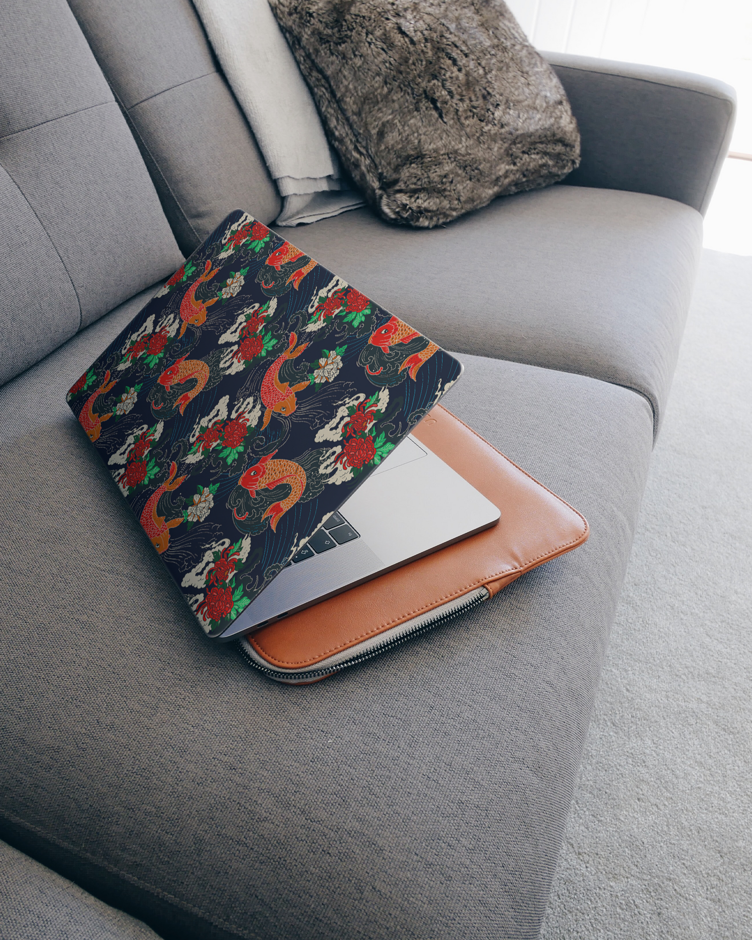 Repeating Koi Laptop Skin for 15 inch Apple MacBooks on a couch