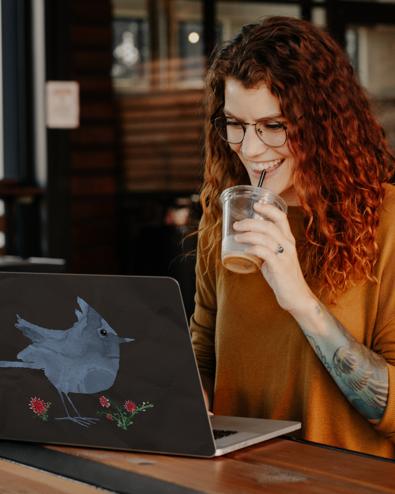 Watercolour Bird Black Laptop Skin for 13 inch Apple MacBooks in a bar