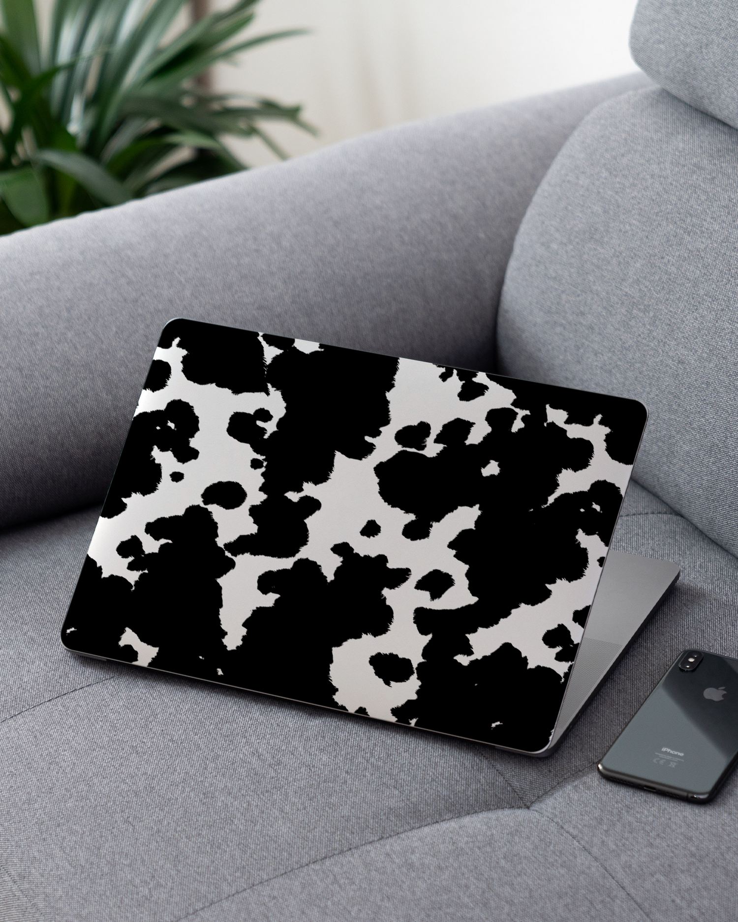 Cow Print Laptop Skin for 13 inch Apple MacBooks on a couch