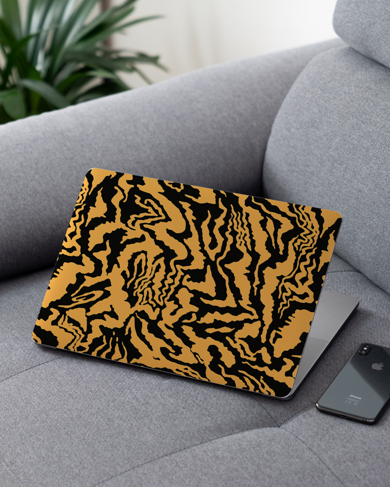 Warped Tiger Stripes Laptop Skin for 13 inch Apple MacBooks on a couch