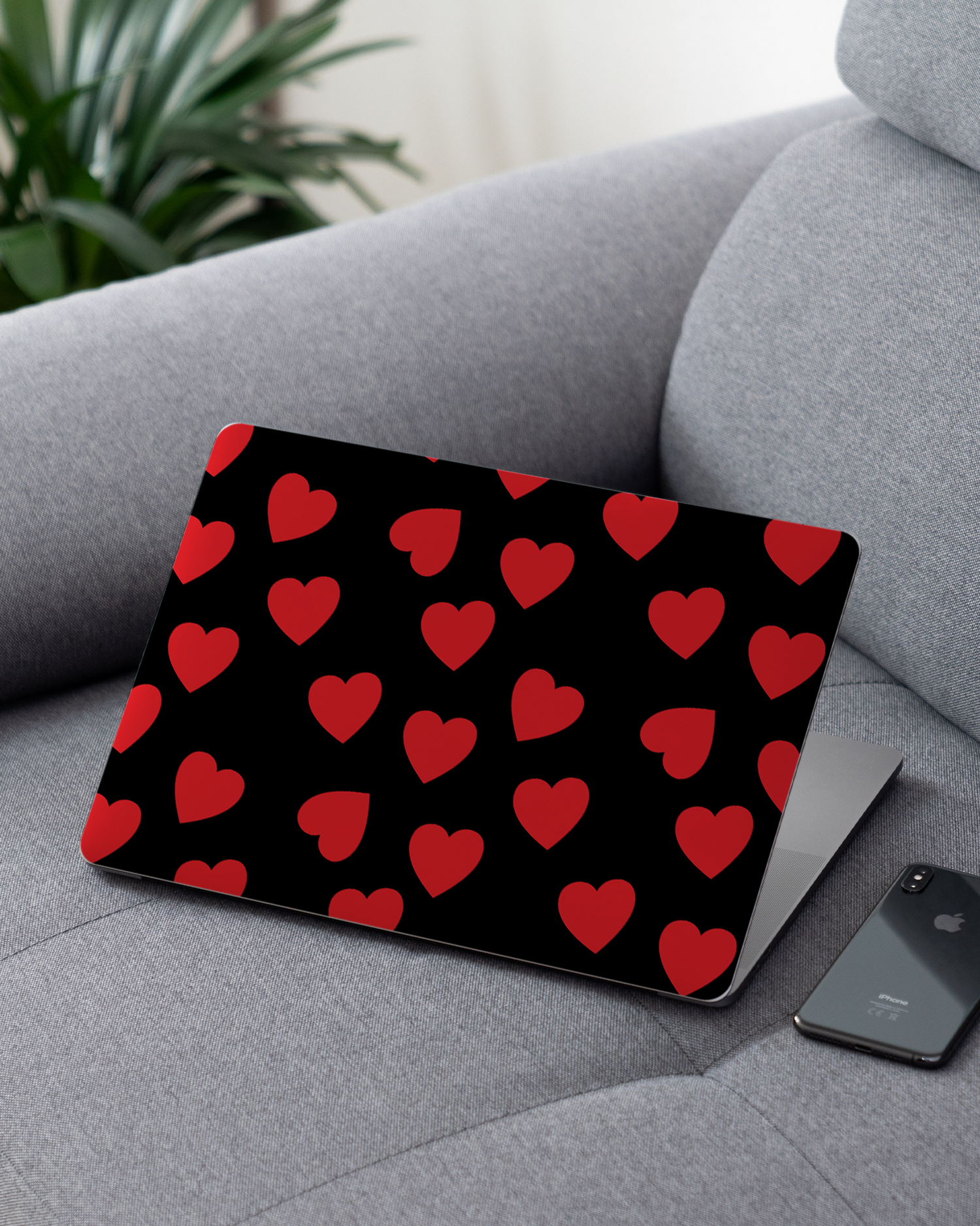 Repeating Hearts Laptop Skin for 13 inch Apple MacBooks on a couch