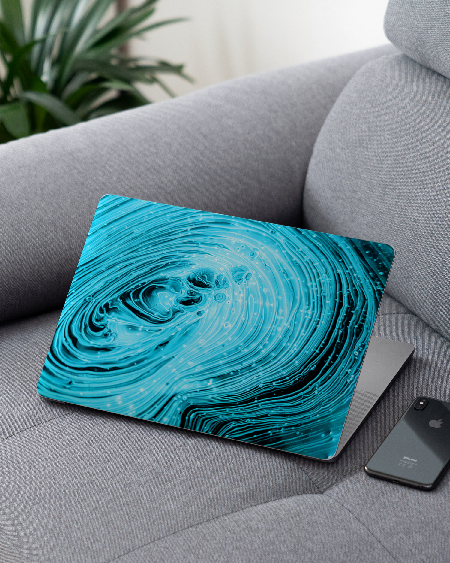 Turquoise Ripples Laptop Skin for 13 inch Apple MacBooks on a couch